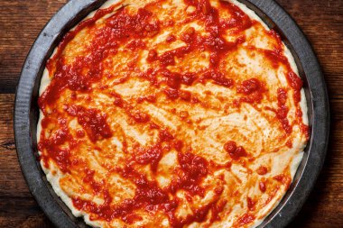 Pizza pişirme. Domates sosuna bulanmış hamur..