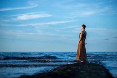 Okyanusta bir kadın uzaklara bakar. Hayaller, depresyon, yansımalar.