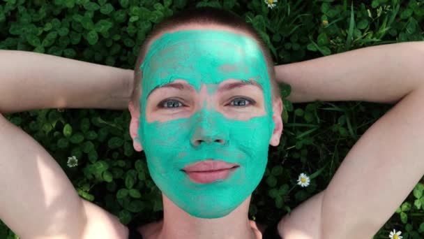 Yüzünde Yeşil Kozmetik Maske Olan Kadın Çimlerin Üzerinde Yatıyor — Stok video