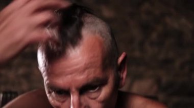 Kafası karışmış ve öfkeyle bağıran şık bir saç kesimi olan yaşlı bir adamın video portresi. Hoşnutsuzluk, saldırganlık.