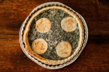 Donmuş peynir ve ıspanaklı kiş resmi, yemek hazırlığın için mükemmel bir yarı bitmiş ürün, ahşap bir arka planda.