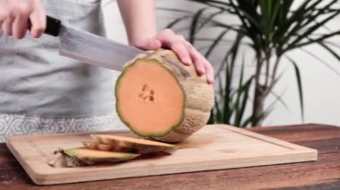 Bir kadın yaz ürünlerinin bolluğunun sembolü olan kavun salatası hazırlıyor.