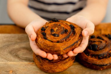 Küçük bir aperatif zevki: Bir delikanlının elleri tatlı yuvarlak bir çörek, sevgi dolu bir lokma
