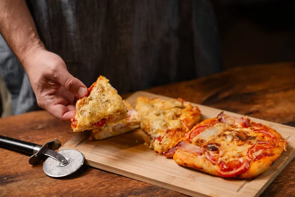 Culinary Delight: A gentleman holds a homemade pizza on a wooden tabletop, inviting you to savor the flavors of his culinary craftsmanship