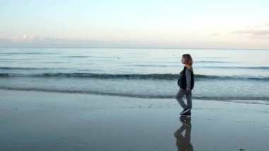 Her adımda, genç bir delikanlı okyanusun kıyısında yürüyor, dalgaların ritmik sesleri onun sahil macerasına rahatlatıcı bir soundtrack sağlıyor.