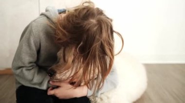 Genç bir çocuk evdeki Kraliyet Kanişi 'ni sevgiyle okşar. Aralarındaki bağ nazik dokunuşlarda ve köpeğin içerik ifadesinde bellidir.