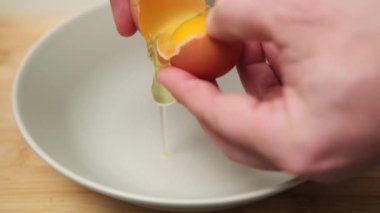 Tavuk yumurtasını bir tabağa koyup, pişirmeye hazırlanmak.