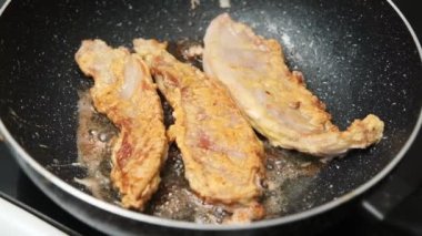 Domuz filetosu dilimleri, hamurla kaplanmış, tavada cızırdıyor.