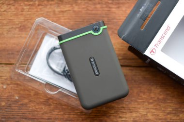 Caen, Fransa - 12 Aralık 2023: Tahta bir yüzeyde taşınabilir yeni bir sabit diskin kutusunu açmak