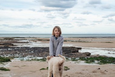 Dalgalı saçlı genç bir çocuğun bağlandığı ve köpek arkadaşına...