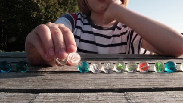 Ung Pojke Leker Med Glas Färgglada Bollar Träyta Sommaren Solens — Stockvideo
