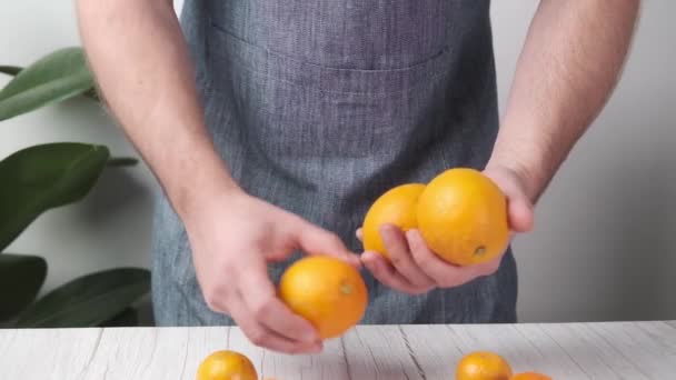Ανδρικά Χέρια Σεφ Παίζουν Πορτοκάλια Ένα Ελαφρύ Φόντο Στην Κουζίνα — Αρχείο Βίντεο