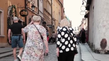 Varşova, Polonya - 20 Temmuz 2023: İki yaşlı kadın Eski Şehir caddesinde yürüyor