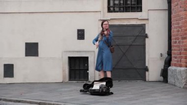 Varşova, Polonya - 20 Temmuz 2023: Kadın sokak müzisyeni Old Town caddesinde keman çalıyor