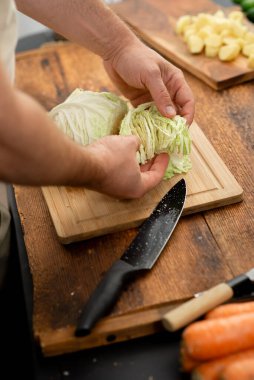 Evde yemek yapmak: akşam yemeği için bambu tahtasında lahana doğramak.