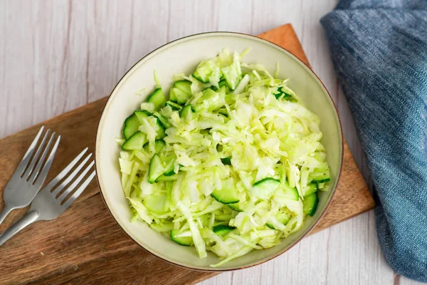 Sebze Lezzeti: Bir tabak lahana salatası içinde lahana ve salatalık var.