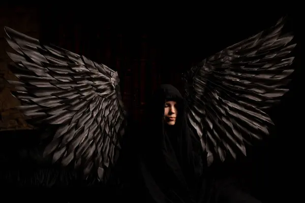 A woman with black angel wings is a reminder that we are all capable of great good and great evi.