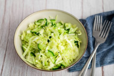 Lahana ve salatadan yapılmış lezzetli lahana salatası, ahşap bir yüzeyde servis edilir.