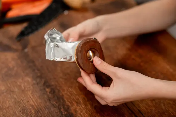 Uma Pessoa Está Segurando Donut Sua Mão Com Papel Alumínio Fotografias De Stock Royalty-Free