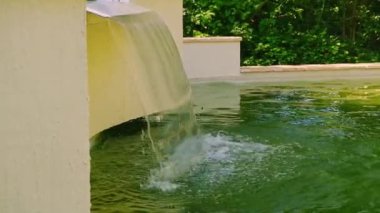 Huzurlu bir şelale sakin bir havuza akar ve rahatlatıcı bir atmosfer yaratır..