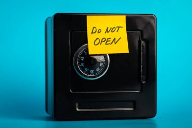 Şifreli kilit ve uyarı notuyla birlikte parlak mavi bir arka plan üzerine siyah kasayı güvene alın..