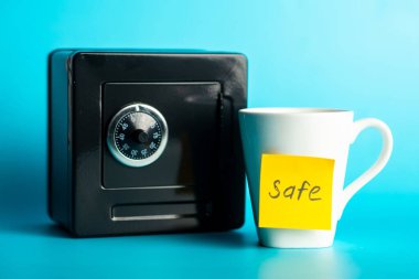 Mavi arka planda 'güvenli' notu olan siyah ve beyaz kupa.