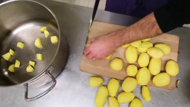 Uzman aşçı profesyonel mutfakta patatesleri ustalıkla doğruyor..