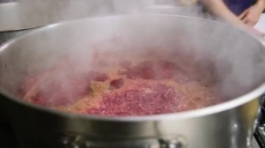 Büyük tencerede sığır eti pişirmek, buharı üstünde çalışmak ve sulu dokuya odaklanmak..
