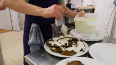 Şef, profesyonel mutfakta krema soslu lezzetli çıtır köfteler hazırlıyor..