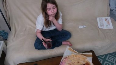 Meraklı çocuk ev yapımı turtayı ve içkiyi rahat bir koltukta inceliyor..