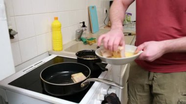 Aşçılık dizisi: Adam ev mutfağında sobanın üstünde ekmek tabağı hazırlıyor..