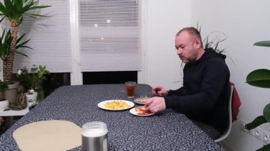 Adam rahat yemek ortamında köpekle sıradan bir akşam yemeğinden hoşlanıyor..