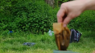 Bir insan elinde bir parça yiyecek tutar ve onu bir bardağın üzerine koyar. Fincanın içi kahverengi bir sıvıyla dolu, ve kişi yiyeceği içine daldırmak üzere.