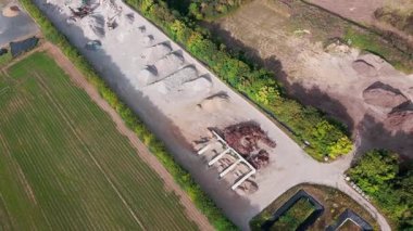 Uçsuz bucaksız tarım arazileri ve kırsal yolda giden arabanın havadan görünüşü.