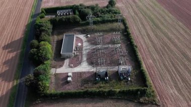 Uçsuz bucaksız tarım arazileri ve kırsal yolda giden arabanın havadan görünüşü.