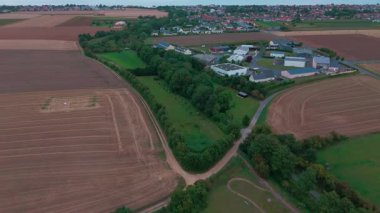 Uçsuz bucaksız tarım arazileri ve kırsal yolda giden arabanın havadan görünüşü.