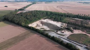 Uçsuz bucaksız tarım arazileri ve kırsal yolda giden arabanın havadan görünüşü.