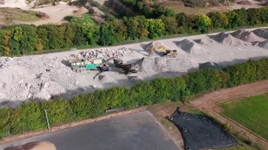 Kazıcıların taşıma araçlarına çakıl yüklediği taş ocağının hava görüntüsü.