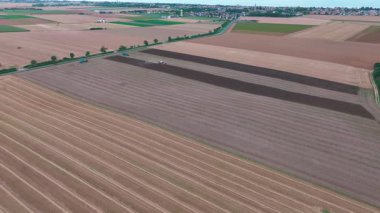 Değişen gölgeler ve güneş ışığı altında geniş tarım alanlarının hava manzarası.