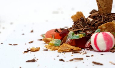 Gurme beyaz ve kırmızı, jöle, çikolata kabukları, beyaz arkaplanda şekerler