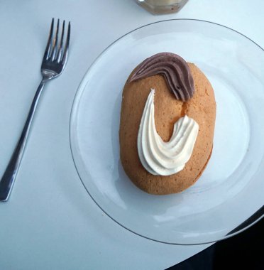 Tatlı, küçük oval pasta, kakaolu pasta ve vanilyalı bir tabak.