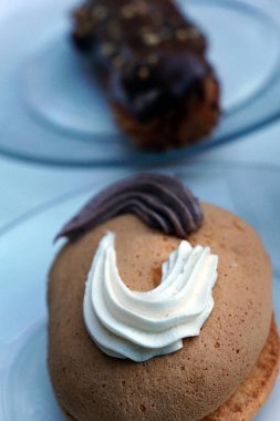 Tatlı, küçük oval pasta, kakaolu pasta ve vanilyalı bir tabak.