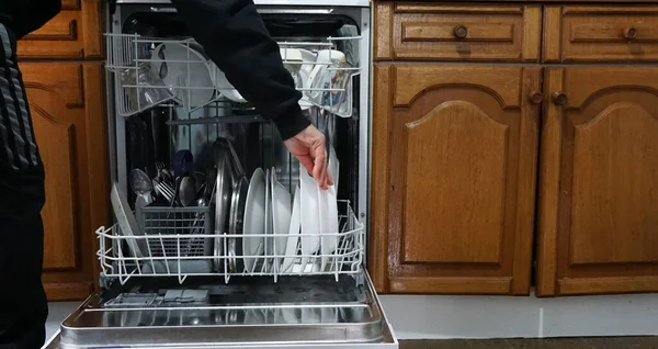 Open dishwasher with dirty dishes in the kitchen.
