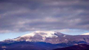 view of a mountain covered with snow , Magical winter forest. Natural landscape with beautiful clouds . The revival of the planet