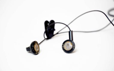 dirty and dusty used black ear buds isolated on white background.