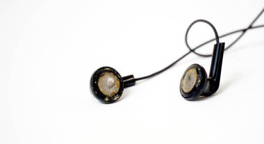 dirty and dusty used black ear buds isolated on white background.