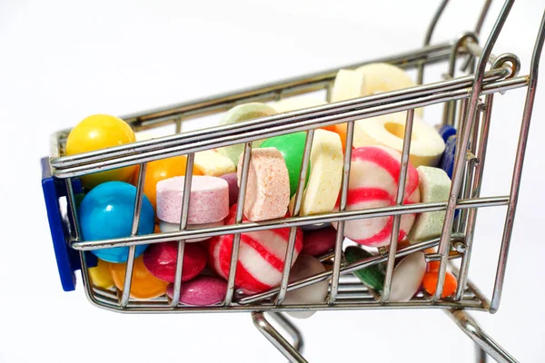 lot of colorful various flavor candies in a small shopping cart.