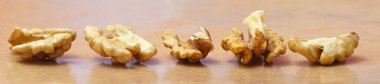 Pieces of a Peeled walnuts on brown background.