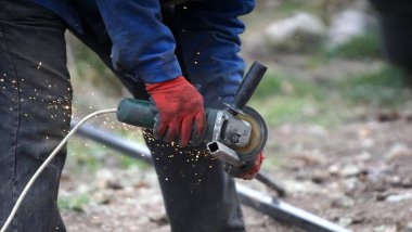 Metal processing with grinder. cutting metal on location of conctruction site, Sparks in metalworking