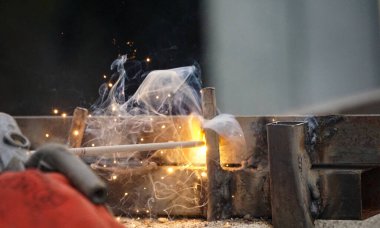 welder is welding metal part on a construction site .